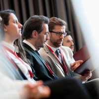 Businessmen discussing over file during seminar