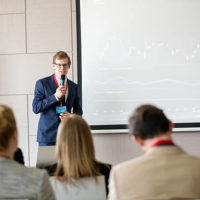 Confident businessman giving presentation in seminar hall at convention center